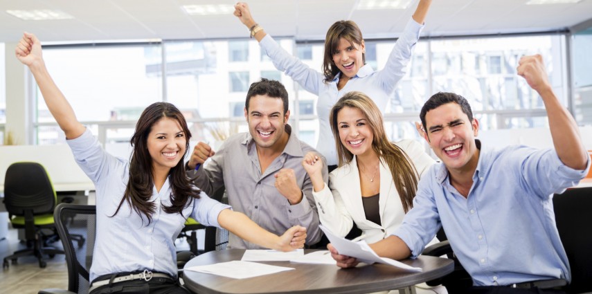 Successful business team with arms up at the office